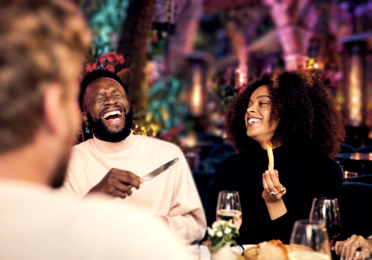 Guests laughing together over dinner in the Garden
